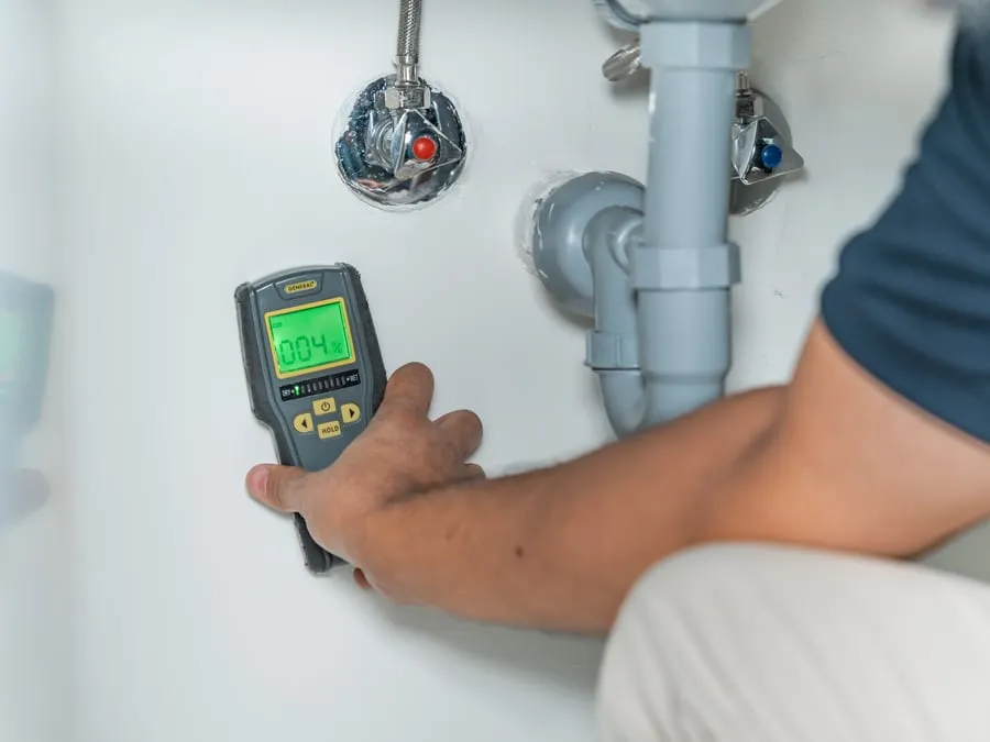 Moisture meter on plumbing under a basin