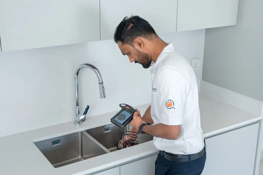 Engineer checking under a kitchen sink